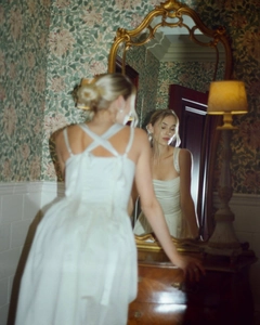 Elegant white satin gown detail with cross-back lace-up design and voluminous tulle skirt