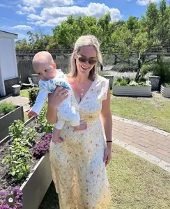 Floral V-neck dress with lace trim shown in a sunny outdoor lifestyle family setting