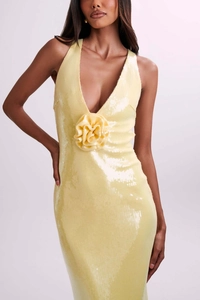 Close-up of elegant pale yellow sequined dress with 3D floral waist detail and V-neck