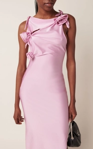 Détail d'une robe en satin rose avec décoration florale 3D et décolleté asymétrique