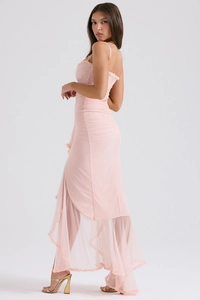Détail de la robe rose clair à coupe asymétrique avec volants et plis à la taille