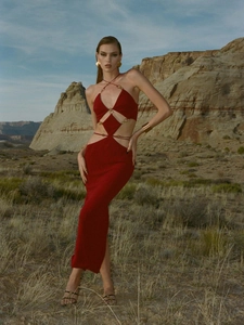 Detail of red hollowed-out maxi dress featuring diamond waist cutouts and metal ring links