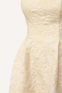Détail de la robe jacquard jaune clair montrant la texture florale et la taille haute