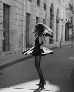 Dynamic motion shot of a backless black flared dress spinning on a city street