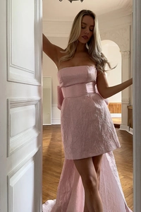 Détail de robe de soirée rose sans bretelles avec grand nœud au dos et tissu jacquard