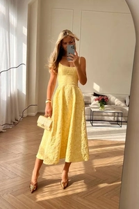 Détail d'une robe midi trapèze jaune avec des motifs floraux en jacquard texturé