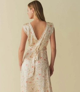 Detail of floral backless dress with lace trim and elegant ribbon bow tie waist
