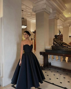 Dettaglio di un elegante abito da sera nero senza spalline con ampia gonna in raso in sala