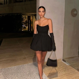 Elegantes trägerloses schwarzes Minikleid mit Faltenrock und langen Handschuhen