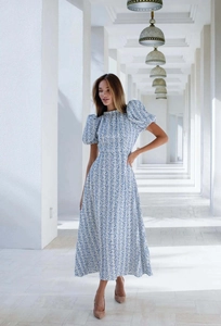 Dettaglio di abito midi floreale azzurro con maniche a sbuffo e scollo alto elegante