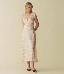 Detail of V-neck floral dress with delicate lace trim and red pastoral flower print