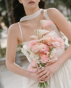 Detail of elegant white satin halter neck dress with scarf tie and draped waistline