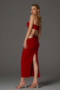 Detailed view of red backless maxi dress with side cut-outs and metal ring accents