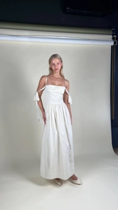 Detail of elegant white satin dress with pleated bodice and ribbon bow sleeves