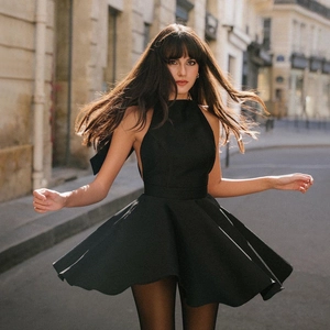 Elegant black halter mini dress with a large bow tie back and flared skirt design