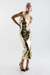 Close-up of golden sequins on a slim fit evening dress with delicate spaghetti straps