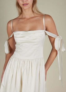 Close-up of pleated ivory satin bodice with delicate shoulder straps and adjustable bow ties