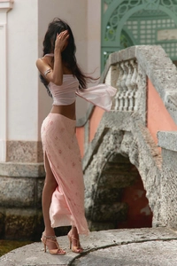 Detailed view of pink sequin floral embroidery and high side slit on beach skirt