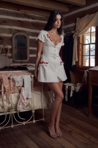 Close-up of deep V-neck white dress with red rose embroidery and lace details