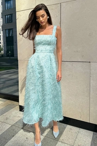 Close-up of light blue evening dress featuring intricate feather-like fringe texture details