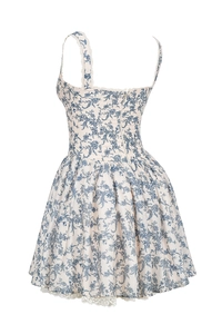Détail de l'imprimé fleuri bleu sur mini robe blanche avec ourlet en dentelle délicate
