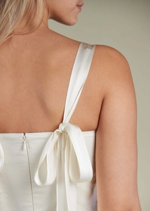 Detail of elegant satin dress with back ribbon bow straps and invisible zipper closure