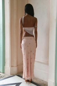 Close-up of pink long skirt featuring intricate sequin flowers and wave-shaped beadwork
