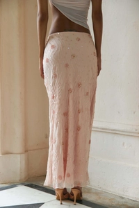 Detail of light pink sequined skirt with 3D floral embroidery and wavy textured fabric