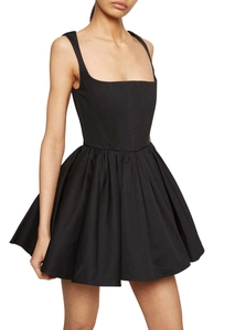 Détail d'une mini-robe noire trapèze avec encolure carrée et larges bretelles plissées