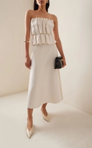 Detail of elegant white pleated strapless top and matching A-line midi skirt outfit