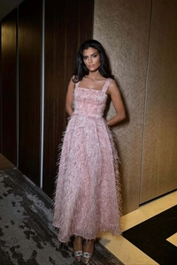 Detail of elegant pink evening dress showing delicate feather textures and shimmering sequins