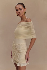 Detailed close-up of ruched cream mesh dress showing layered off-shoulder fabric texture