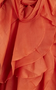 Detail of coral orange tiered ruffle design on a lightweight chiffon holiday dress