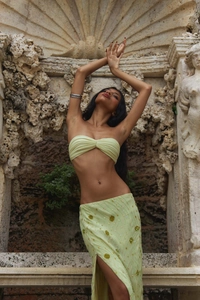 Detail of light green sequins and floral embroidery on a high slit vacation skirt