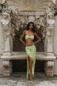 Detail of light green sequined maxi skirt with high side slit and intricate embroidery