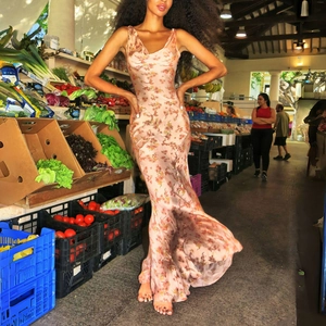 Elegant floral maxi dress with cowl neck and slip straps shown in a vibrant market scene