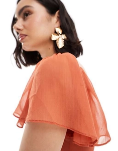 Detail of oversized gold floral earrings with pearl and coral chiffon ruffled dress