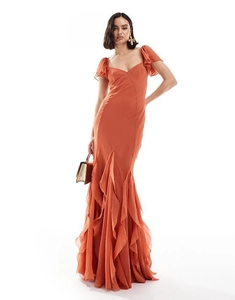 Detail view of the rust-colored ruffle sleeves and mermaid hem on this elegant maxi dress