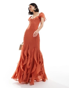 Detail of rust-colored maxi dress featuring elegant ruffle sleeves and mermaid hemline