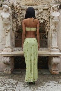 Detail of sequin floral embroidery on a backless green maxi skirt with fishtail hem
