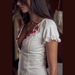 White deep V-neck dress featuring delicate red rose embroidery and lace details