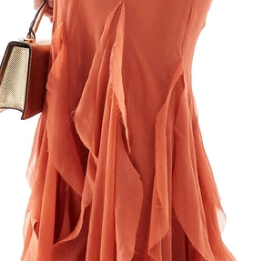 Detail of caramel orange dress with tiered ruffles and deconstructed raw edge texture