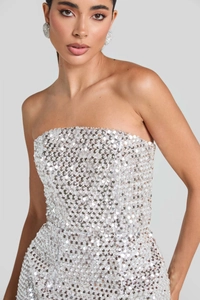 Close-up of silver sequined sleeveless dress fabric with matching round textured earrings