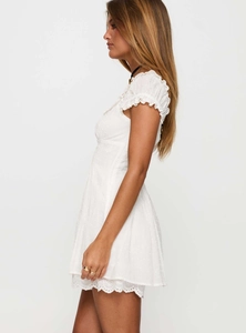 Close-up detail of white lace eyelet embroidery and square neck on slim summer dress