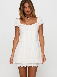 Close-up of white summer dress featuring square neckline with delicate lace eyelet details