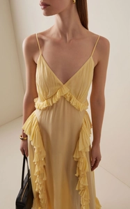 Détail du décolleté en V profond et des volants superposés sur une robe d'été jaune