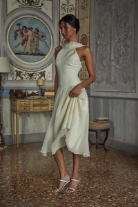 Detail of elegant halter neck cream chiffon dress with pleated ruffles and midi length
