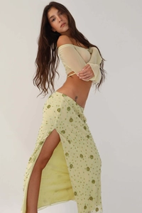 Detail of high side slit on long skirt with green sequin floral embroidery and sheer fabric