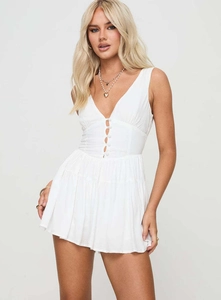 Détail d'un combishort blanc sans manches avec décolleté en V, boutons et découpes