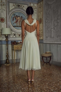 Detail of elegant cream-white chiffon evening dress showing cowl neck and back design